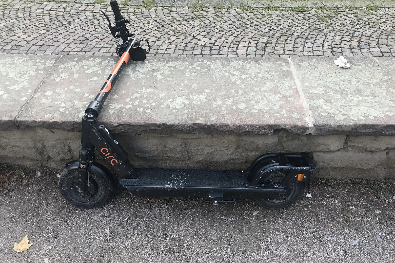 Katkise juhtrauaga elektritõukeratas madala kivimüüri ääres